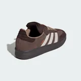 Championes Adidas modelo Samba XLG, de diseño urbano con suela de plataforma. Presentan una combinación de tonos marrones en gamuza y cuero, con las icónicas tres franjas laterales en color beige y detalles en naranja vibrante en la lengüeta y el lateral.
