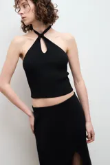 Top halter negro de punto acanalado con cuello halter y abertura en forma de gota en el centro del pecho.
