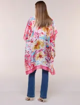 Kimono de satén ligero con estampado floral en tonos rosados, amarillos y celestes, de silueta amplia y diseño abierto al frente con mangas cortas amplias.
