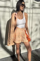 Short sastrero de lino con estampado de rayas verticales naranjas y blancas, corte holgado.