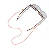 Correa para lentes de cuentas rojas semitransparentes con enganches dorados. Puede usarse como collar o sujetador de mascarillas.