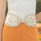 Cinto faja color crudo de cuero con tachas doradas y hebilla metálica.