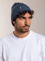 Gorro de lana azul con etiqueta de cuero sintético con logo de la marca en el frente.
