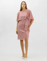 Vestido midi de tejido metalizado color turquesa, con sobrecapa de tul liviano sobre los hombros, detalle de pedrería en la cintura, volado lateral y tajo frontal.