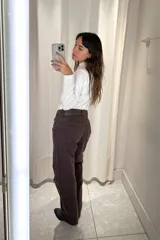 Pantalón de jean corte wide leg color marrón oscuro, con tiro medio y cierre frontal con botón metálico.