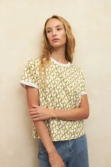 Remera de manga corta color beige con estampado abstracto en negro y dobladillo en las mangas.