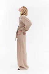 Pantalón sastrero de lino italiano color beige, de corte recto y holgado, con aberturas laterales en la cintura y pinzas.