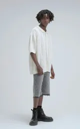 Camisa de punto abierto (crochet) color beige, manga corta y cuello polo, con calce oversize.