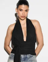 Top halter negro de escote profundo en V, con espalda descubierta, detalle fruncido en la cintura y lazo largo delantero ajustable.
