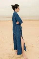 Tapado largo de jean con dos amplios tajos laterales que le dan movimiento y estilo. Cuenta con dos grandes bolsillos delanteros y un botón de guampa, distintivo de la marca.