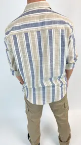 Camisa de cuello italiano, semi entallada, con rayas verticales en tonos azul, beige y blanco.