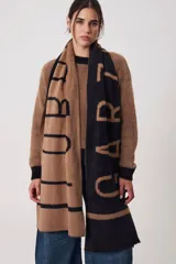 Bufanda rectangular de tejido suave, color negro con letras grandes en color beige que forman la palabra 'LODOS'.