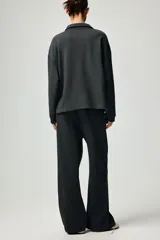 Jogging de felpa liviana en color gris oscuro, con cintura elástica ajustable mediante cordón, bolsillos laterales discretos y diseño de piernas rectas.