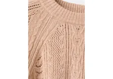 Sweater de punto color tostado, de cuello redondo y mangas largas con diseño texturizado de ochos y detalles calados.