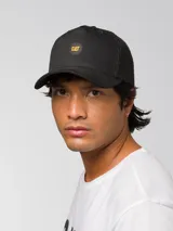 Gorro tipo trucker color negro con panel frontal de tela y parte trasera de malla. Presenta un parche circular con el logo de CAT en amarillo y negro en el frente y cierre deslizante ajustable en la parte posterior.