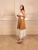 Vestido largo sin mangas, con escote en V y diseño de bloques de color. La parte superior es blanca, la sección media es color camel/marrón claro, y el ruedo inferior es blanco.