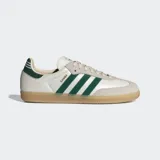 Championes Adidas modelo Samba OG, con diseño clásico de perfil bajo. Presentan una base de cuero color crema con superposiciones de gamuza gris en la puntera y los ojales. Incluyen las icónicas tres rayas laterales y el detalle en el talón en color verde oscuro, con suela de goma color caramelo.