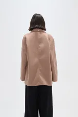 Tapado de paño color gris, con cuello camisero, cierre frontal de botones y bolsillos laterales con solapa.