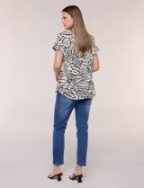 Blusa de silueta holgada y recta, confeccionada en crepe de poliéster con estampado animal print. Presenta escote redondo clásico, mangas cortas de hombro caído con puño doblado y ruedo ligeramente curvo.