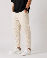 Jean slouchy de color beige, con corte holgado en las piernas y botamangas ligeramente ajustadas o dobladas.