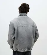 Campera de jean para hombre de corte boxy, con lavado gris de efecto desgastado, cuello camisero, cierre frontal con cremallera y bolsillos delanteros.