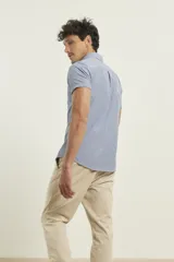 Camisa manga corta con cuello abotonado y estampado a cuadros pequeños en tonos rojo y blanco.