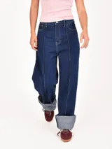 Jean de mujer color azul oscuro, de corte recto y tiro alto, con costuras verticales decorativas en la parte delantera de las piernas. Presenta dobladillo ancho en los tobillos.