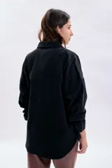 Sobrecamisa de pana en color gris oscuro, con cierre frontal de botones metálicos, cuello clásico y bolsillos frontales.