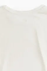 Remera deportiva de corte boxy y holgado, confeccionada en tejido funcional con tecnología DryMove que absorbe el sudor. Presenta cuello redondo, mangas cortas con hombros caídos y bajo recto.