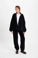 Pantalon de tiro bajo con diseño híbrido que combina elementos formales y deportivos. Presenta cintura y bajos ajustables, con elástico en la parte trasera de la pretina interna.