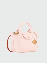 Cartera de mano Longchamp modelo Le Pliage Xs en color rosado, confeccionada en cuero con asas superiores, solapa con broche de presión y herrajes metálicos dorados.