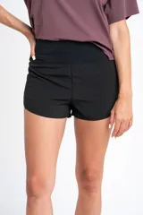 Short negro de tiro medio con corte ligeramente acampanado, confeccionado en tejido técnico de secado rápido con cintura elástica ancha.