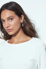 Remera de manga larga con ajuste al cuerpo, confeccionada en tejido acanalado de color marrón. Presenta cuello redondo y terminaciones con borde ondulado en puños y ruedo.