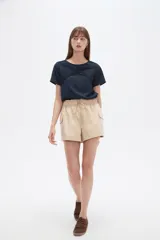 Short cargo negro de poliéster, con cintura elástica fruncida y cordón ajustable. Posee bolsillos laterales tipo cargo.