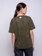 Remera blanca de corte amplio, cuello redondo y manga corta, con diseño de líneas verticales con transparencias.