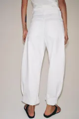 Jeans de tiro medio de corte balloon leg, color blanco, con trabillas en la cintura, diseño de cinco bolsillos, bajo con vuelta y cierre frontal con cremallera y botón.