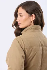 Campera de abrigo color beige con capucha desmontable, cierre frontal y cordón ajustable en la cintura. Cuenta con forro interior de sherpa, bolsillos frontales y puños de tejido acanalado.