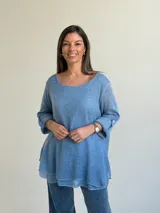Sweater de punto color azul jean, con cuello redondo, mangas largas con vuelta y diseño amplio de corte evasé.