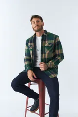 Sobrecamisa de viyela a cuadros rojos y azules con interior capitoneado, corte regular, manga larga, cierre con botones, bolsillos frontales y logo en grifa de cuero.