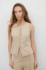 Chaleco de gamuza color caramelo, con cierre frontal de botones y bolsillos laterales simulados.