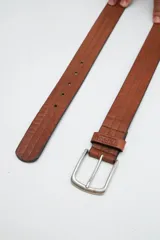 Cinto marrón de cuero con hebilla metálica plateada.