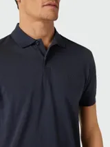 Remera polo de piqué color azul marino de corte regular, con mangas cortas, cuello clásico y tapeta con dos botones. Cuenta con el logo de la marca bordado sutilmente en el pecho.