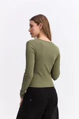 Remera de manga larga color beige, con ajuste al cuerpo y costuras decorativas visibles en el frente que realzan la silueta.