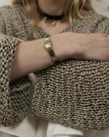 Pulsera tipo esclava abierta de diseño rústico con acabado irregular y textura martillada, fabricada en bronce o alpaca.