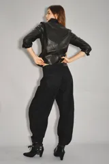 Jean de tiro medio-alto, color negro, de calce holgado con piernas anchas que se estrechan hacia el tobillo. Presenta pinzas en las rodillas que acentúan su forma "balloon" y un recorte lateral. Confeccionado en denim rígido con lavado suavizado, cierre y botón.