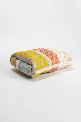 Necessaire acolchado con cierre perimetral, confeccionado en tela con estampado patchwork de motivos florales y geométricos en tonos tierra, mostaza y rosa.