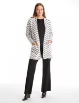 Cardigan de tejido soft con estampado de espiga en blanco y negro, corte recto, manga larga y bolsillos frontales amplios.