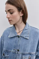 Campera de jean de silueta amplia, con cuello clásico y cierre frontal con botones. Diseño con bolsillos con solapa en el frente y bolsillos laterales, hombros caídos y terminaciones pespunteadas.