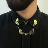 Collar dorado con colgantes de conejo y cristal facetado.
