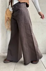 Jean de corte wide leg en color chocolate, confeccionado en denim con costuras verticales decorativas y ruedo deshilachado.